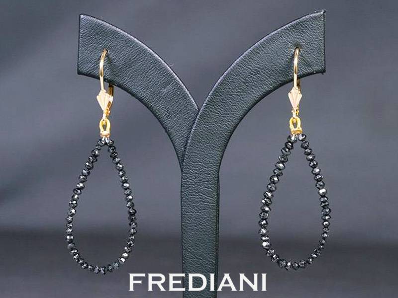 Boucles d'oreilles en or jaune 750/000 et perles facettées de diamants noirs.