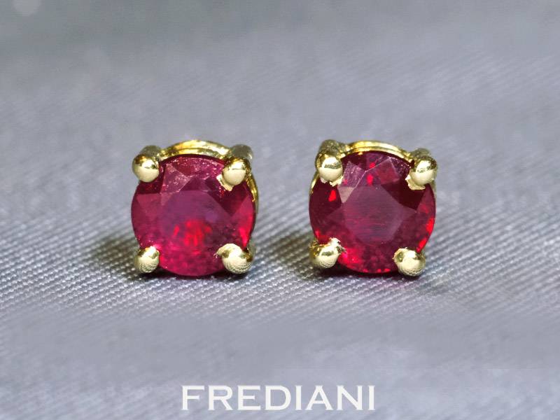 Boucles d'oreilles en or jaune 750/000 et 2 rubis ronds parfaitement appairés.