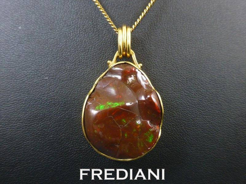 Pendentif en or jaune 750/000 serti d'une opale chocolat naturelle.