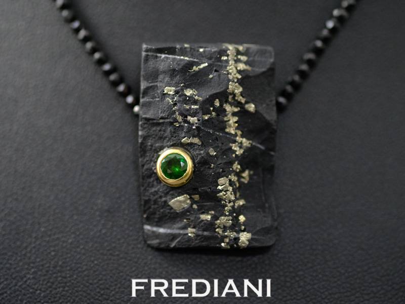 Collier en spinelles noirs finement facettés avec un fermoir en or jaune 750/000. Pendentif en ardoise incrustée de pyrite avec un grenat tsavorite vert serti dans de l'or jaune 750/000.
