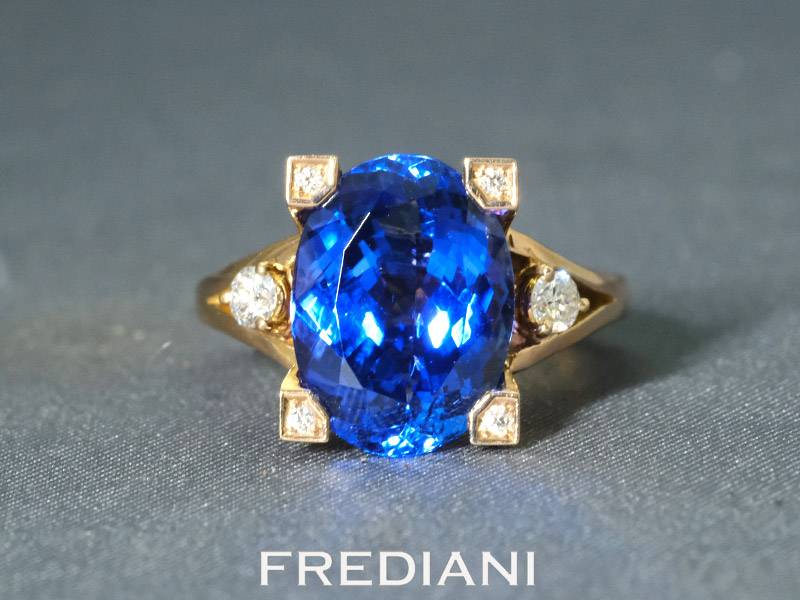Bague en or rouge 750/000 sertie d'une tanzanite ovale de 6.42 carats et accompagnée de 6 diamants.