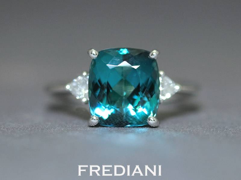 Bague en or blanc sertie d'une tourmaline bleue et 2 diamants triangles