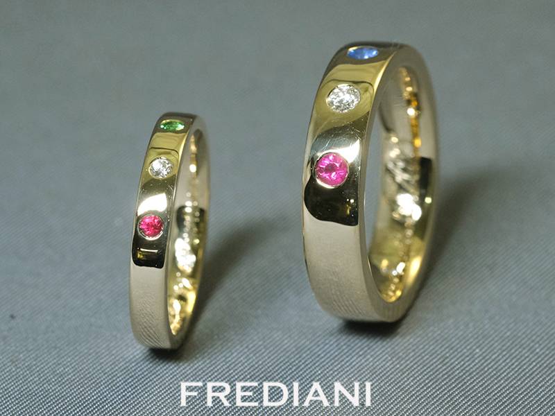 Alliances en or jaune 750/000 serties de pierres précieuses rubis, saphir bleu et diamant naturel.