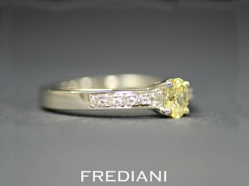 Bague en or blanc sertie d'un diamant jaune et entouré de 10 diamants blancs