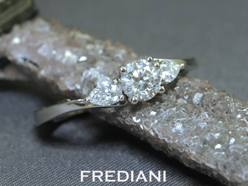 Bague en or blanc 750/000 sertie d'un diamant rond certifié GVS2 entouré de deux diamants poires FVS naturels.