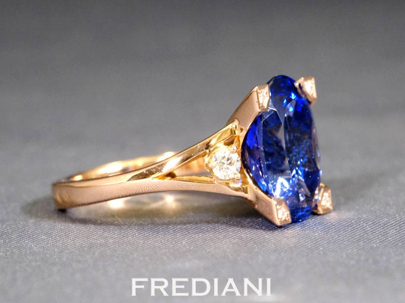 Bague en or rouge 750/000 sertie d'une tanzanite ovale de 6.42 carats et accompagnée de 6 diamants.