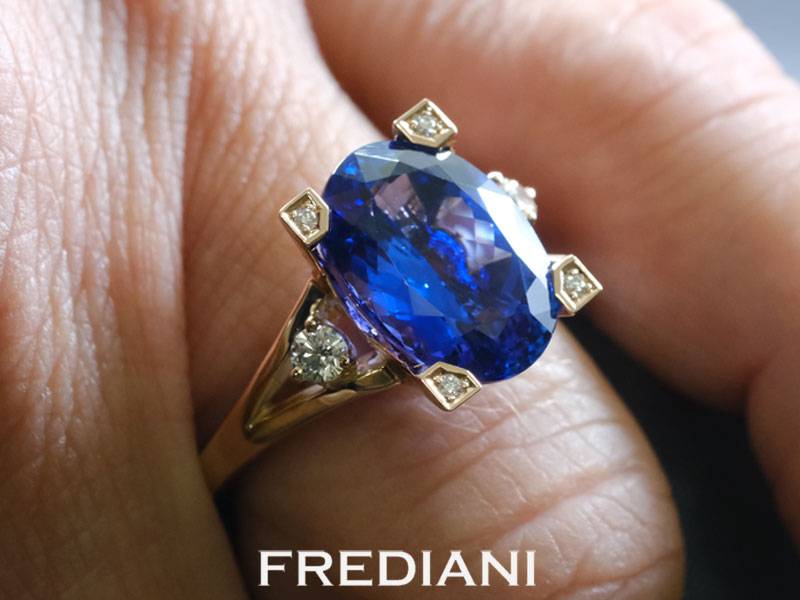 Bague en or rouge 750/000 sertie d'une tanzanite ovale de 6.42 carats et accompagnée de 6 diamants.