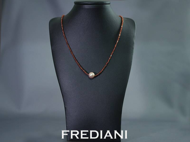 Collier en boules de grenat facettées, perle d'eau douce et fermoir en or jaune 750/000