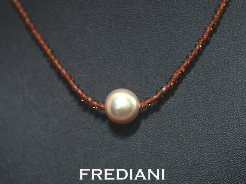 Collier en boules de grenat facettées, perle d'eau douce et fermoir en or jaune 750/000