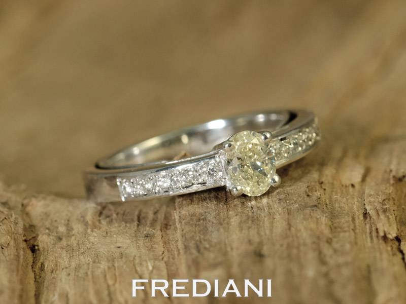 Bague en or blanc sertie d'un diamant jaune et entouré de 10 diamants blancs