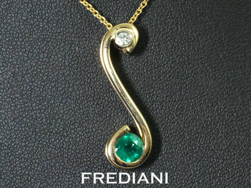 Pendentif en or jaune 750/000 serti d'une émeraude ronde et d'un diamant naturel.
