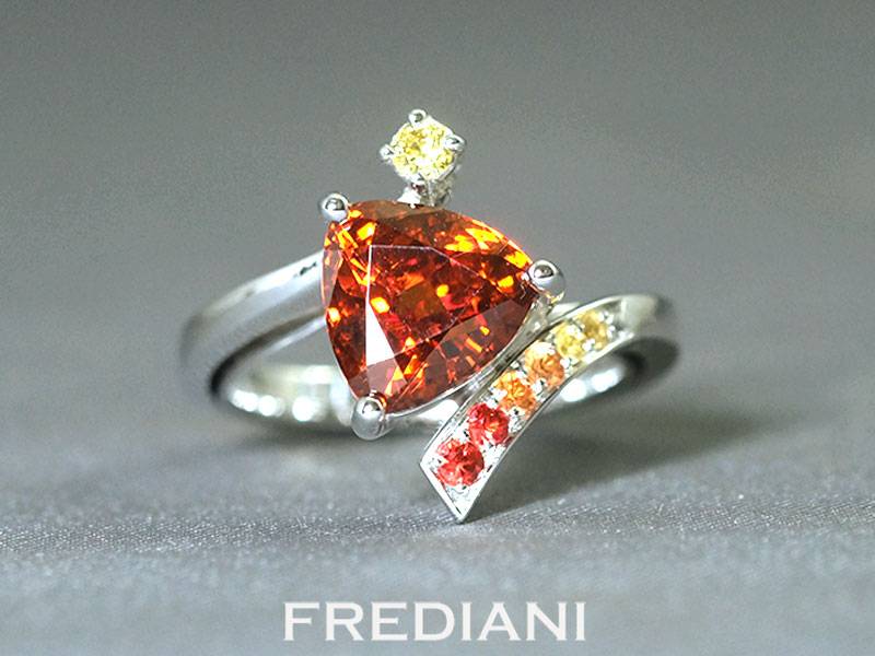 Bague en or blanc sertie d'un grenat spessartite, 6 saphirs de couleurs et 1 diamant jaune naturel