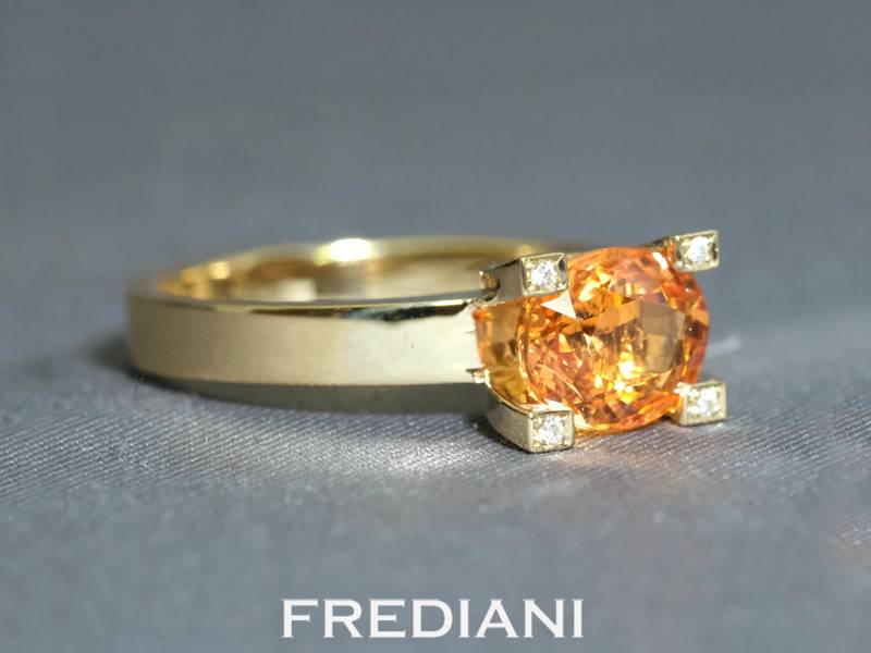 Bague en or jaune 750/000 sertie d'un grenat spessartite naturel ovale et accompagné de 4 diamants blanc naturels sur les griffes.