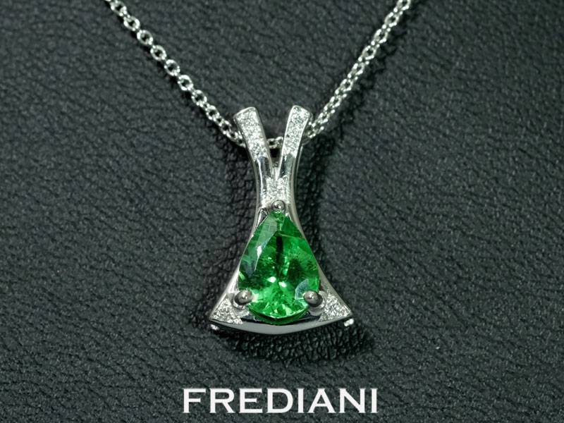 Pendentif en or blanc 750/000 serti d'un grenat vert tsavorite en forme de poire et accompagné de 9 diamants ronds naturels.