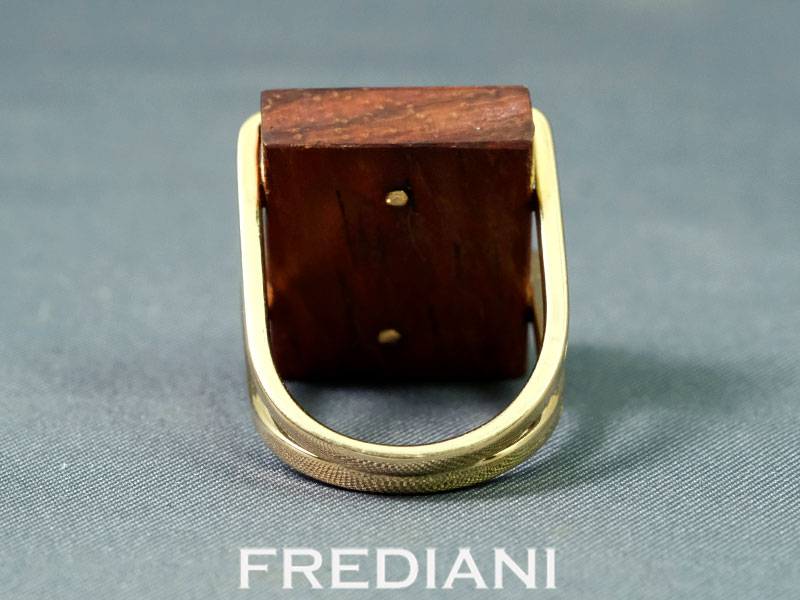 Bague en or jaune sertie d'une opale naturelle sur du bois précieux