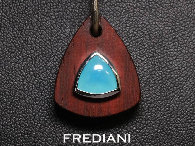 Pendentif en or blanc serti d'une opale bleue naturelle sur du bois précieux