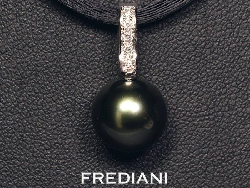 Pendentif en or blanc 750/000 serti d'une perle de culture noire de Tahiti 10.5 mm accompagnée de 5 diamants naturels.
