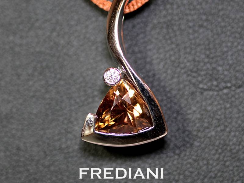 Pendentif en or blanc 750/000 serti d'un zircon brun naturel forme troïdia et d'un diamant blanc naturel.