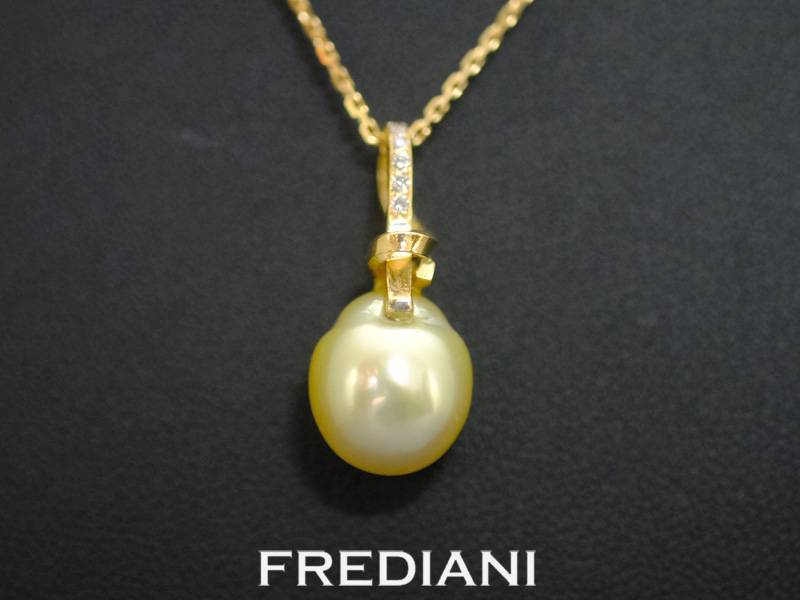 Pendentif en or jaune 750/000 serti d'une perle gold des mers du sud accompagnée de 5 diamants.
