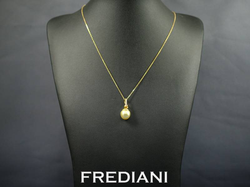 Pendentif en or jaune 750/000 serti d'une perle gold des mers du sud accompagnée de 5 diamants.