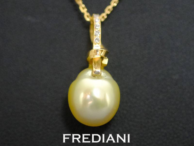 Pendentif en or jaune 750/000 serti d'une perle gold des mers du sud accompagnée de 5 diamants.