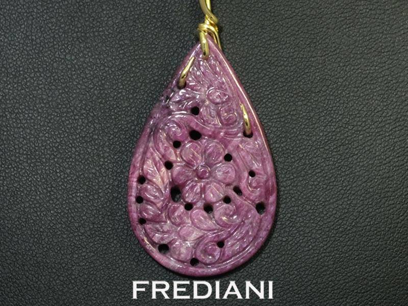 Pendentif en or jaune 750/000 serti d'un magnifique rubis ornemental finement sculpté.