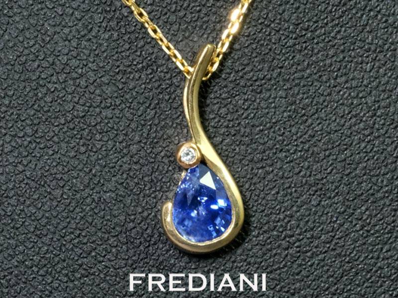 Pendentif en or jaune 750/000 serti d'un saphir bleu en forme de poire et d'un diamant naturel.