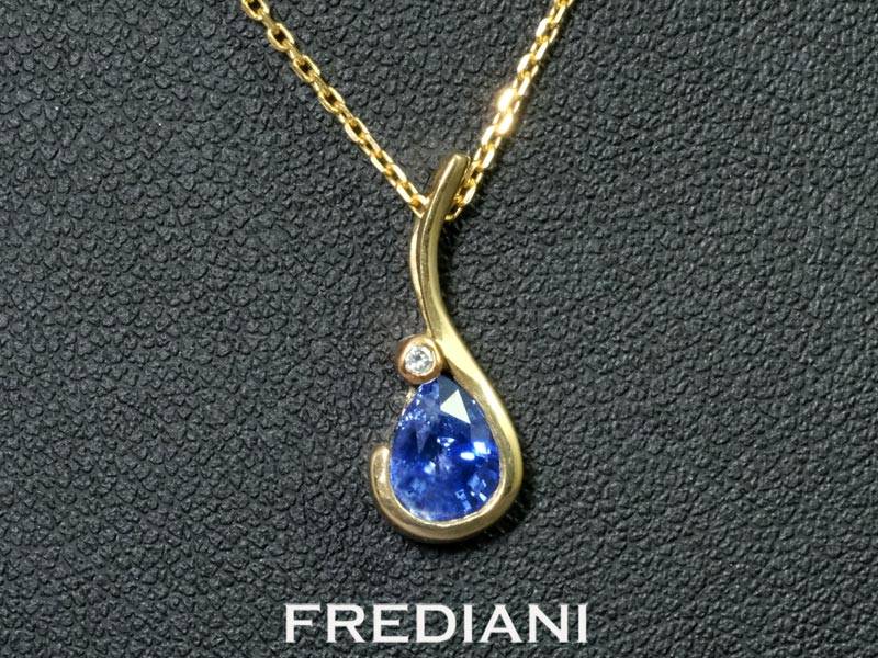 Pendentif en or jaune 750/000 serti d'un saphir bleu en forme de poire et d'un diamant naturel.