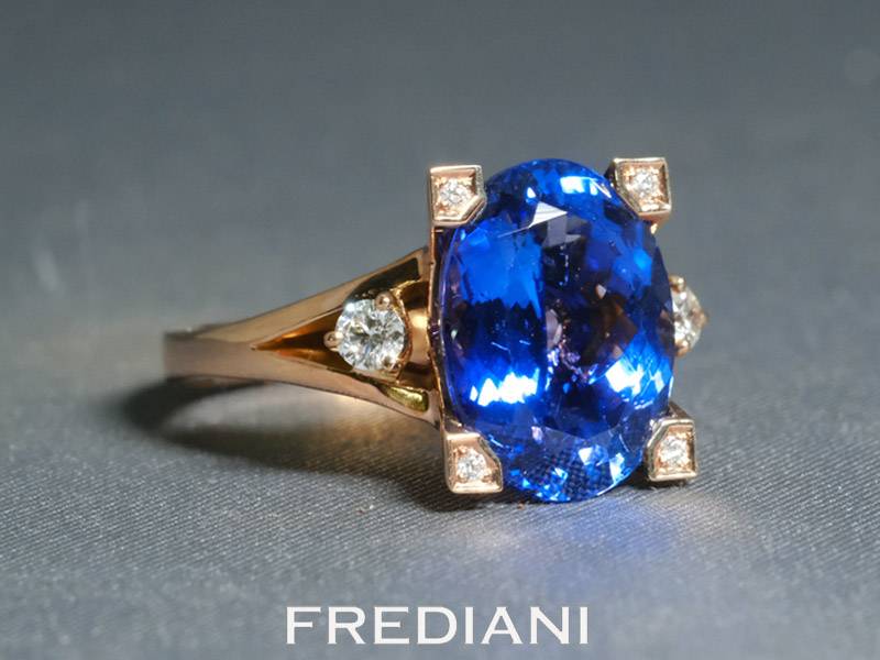 Bague en or rouge 750/000 sertie d'une tanzanite ovale de 6.42 carats et accompagnée de 6 diamants.