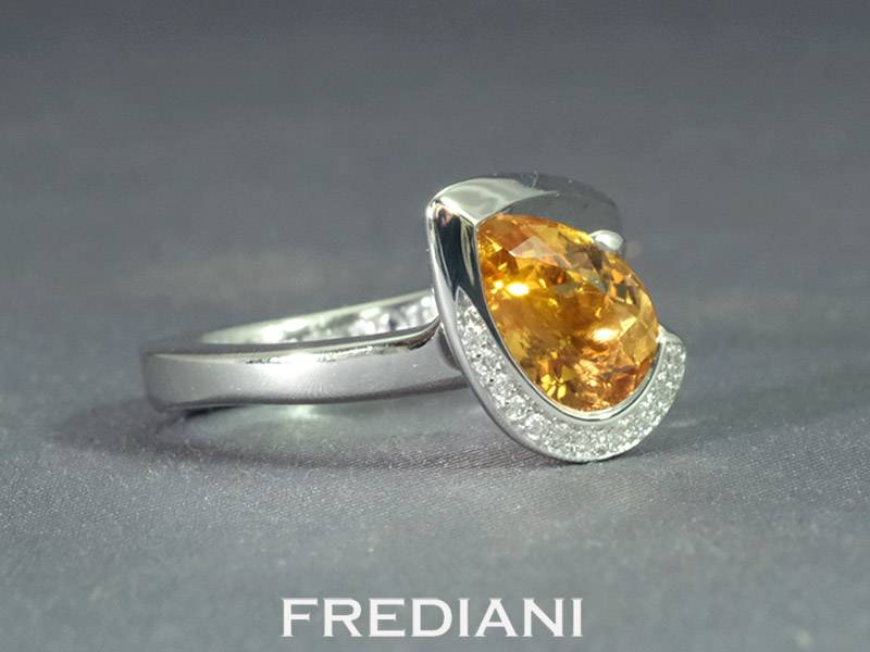 Bague en or blanc sertie d'une topaze impériale et 11 diamants naturels