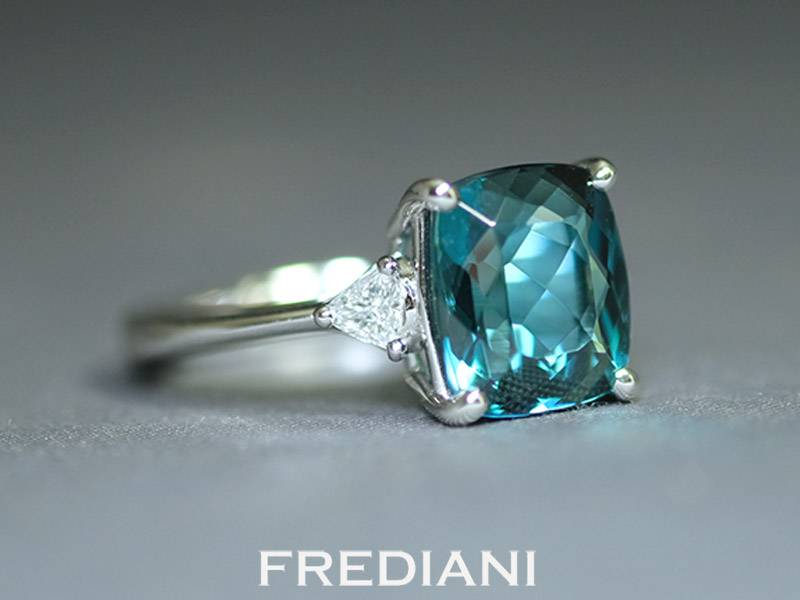 Bague en or blanc sertie d'une tourmaline bleue et 2 diamants triangles