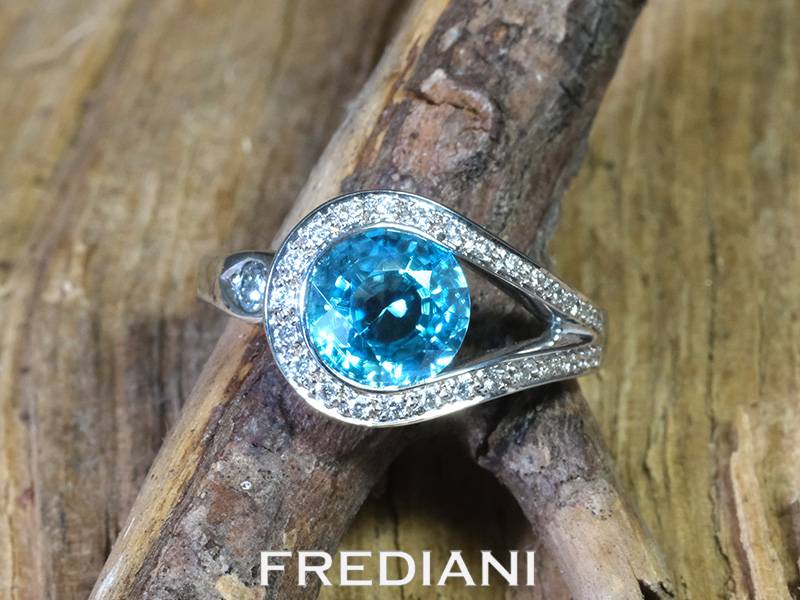 Bague en or blanc 750/000 sertie d'un zircon bleu du Cambodge et accompagné de 28 diamants naturels