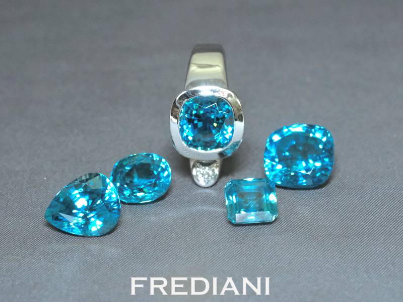 Bague en or blanc 750/000 sertie d'un magnifique zircon bleu coussin et accompagné d'un diamant rond naturel.
