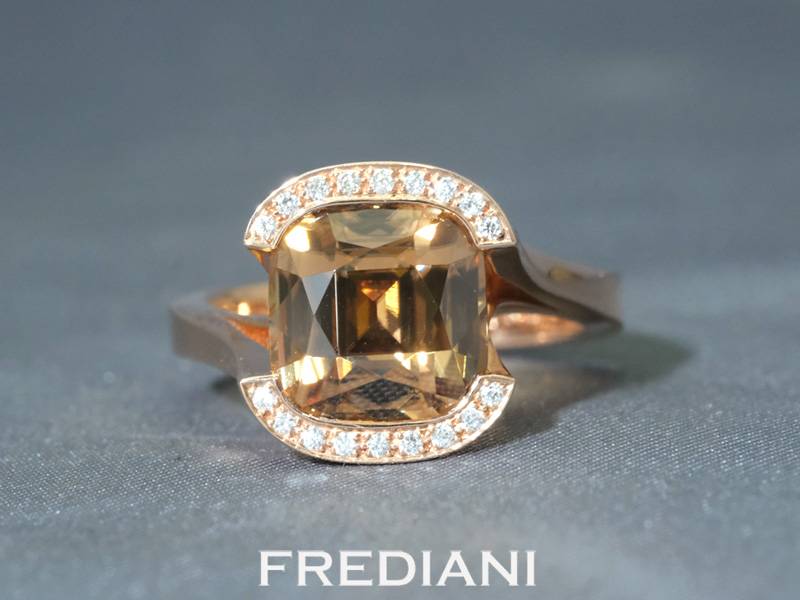 Bague en or rouge 750/000 sertie d'un zircon brun naturel coussin accompagné de 18 diamants.